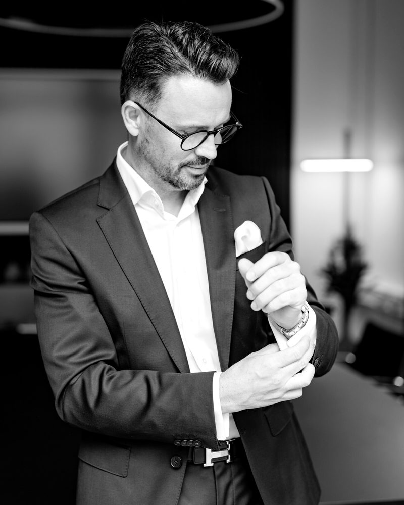 Manfred Braun im dunklen Anzug im Besprechungsraum